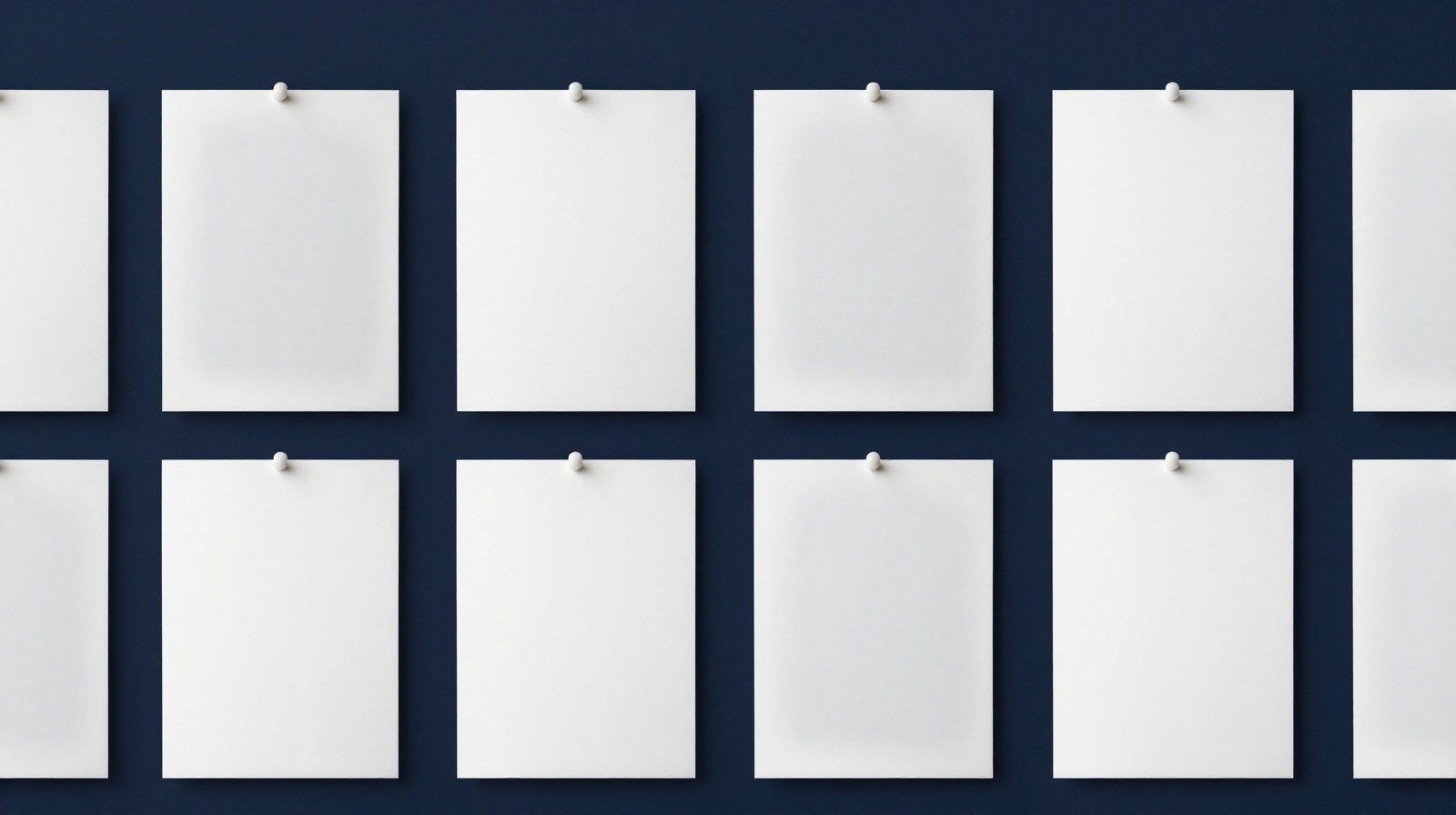 A grid of identical white sheets pinned to a deep navy wall. Most are crisp and solid; a few have faded into the wall, still holding their place